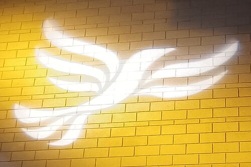 Lib Dem logo bird projected on blockwork