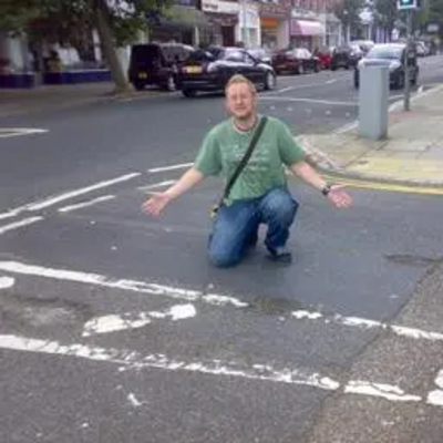 Gary Fuller with pot holes at the junction of Bouverie Road West and Christchurch Road