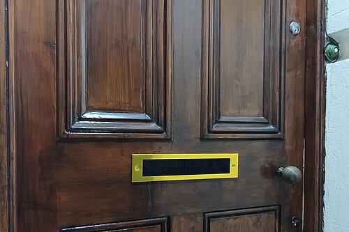Wooden front door with gold letterbox / draught excluder