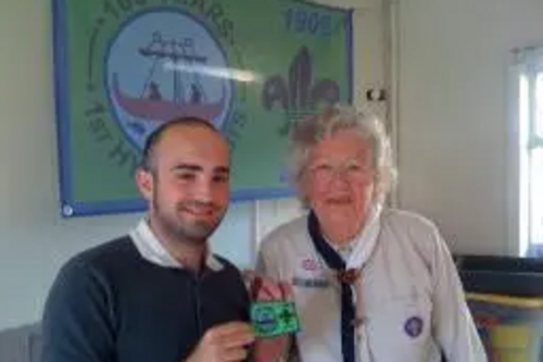 Sam Matthews receives a Cubs Centenary Badge from Phyllis Couchman