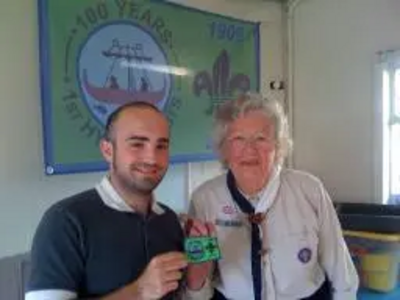 Sam Matthews receives a Cubs Centenary Badge from Phyllis Couchman