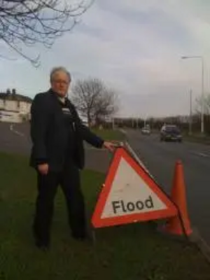 Neil Matthews with flood warning sign