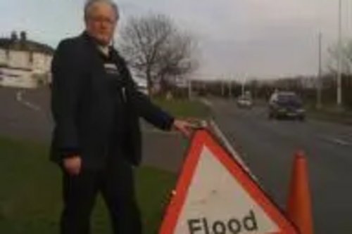 Neil Matthews with flood warning sign